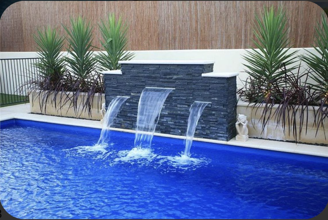 Architectural lighting and custom fountain illuminating a luxury building and landscaped courtyard