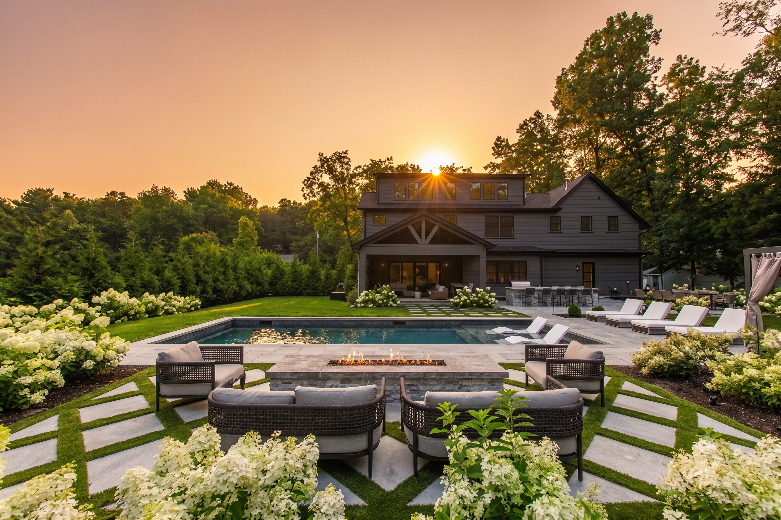 Resort-style backyard with swimming pool, landscaped garden, outdoor lounge, pond, fountain and architectural lighting by GBS Creative